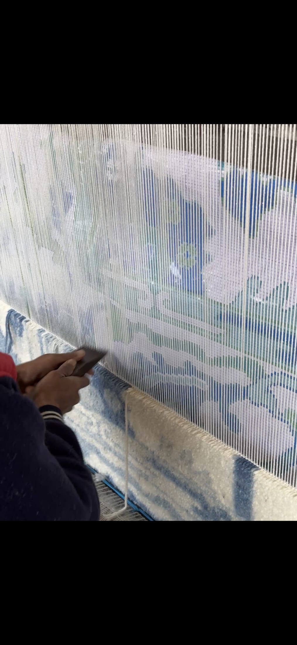 A weaver tying knots at the loom